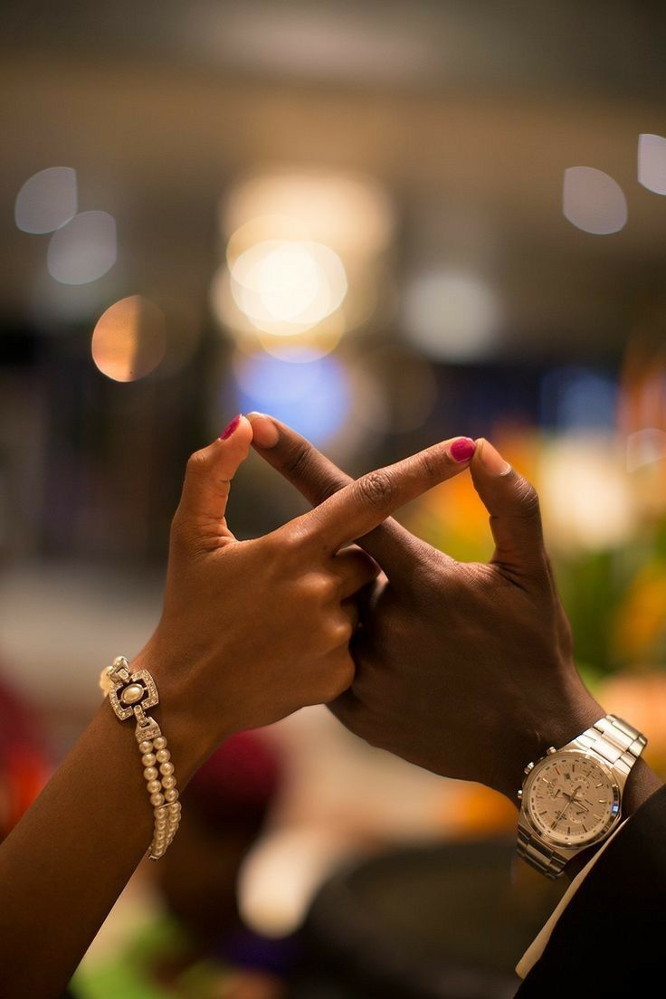 Fingers linked across a table, mid-conversation